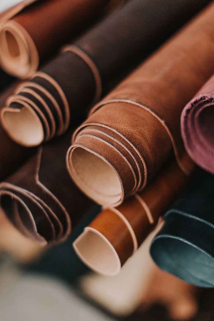 A detailed close-up of various rolled brown leather pieces, highlighting textures.